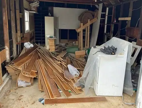 Garage voller Holzbretter, Kisten und eines alten Kühlschranks vor der Räumung