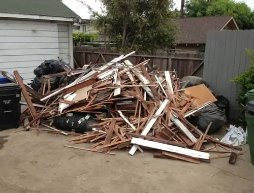 Haufen aus alten Holzlatten und Brettern im Garten vor der Gartenräumung